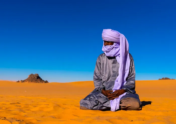 Tuareg Sits In The Sahara Desert, North Africa, Erg Admer, Algeria
