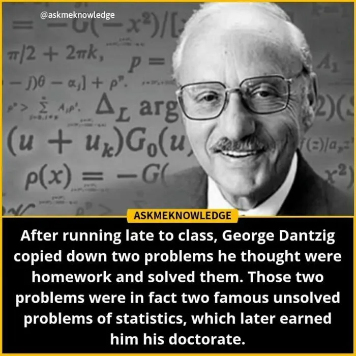 Man with glasses smiles, standing in front of a chalkboard filled with equations, related to interesting facts.