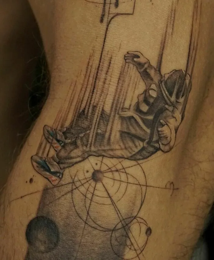 Astronaut in space suit tattoo, depicting outer space theme with planets and geometric patterns.