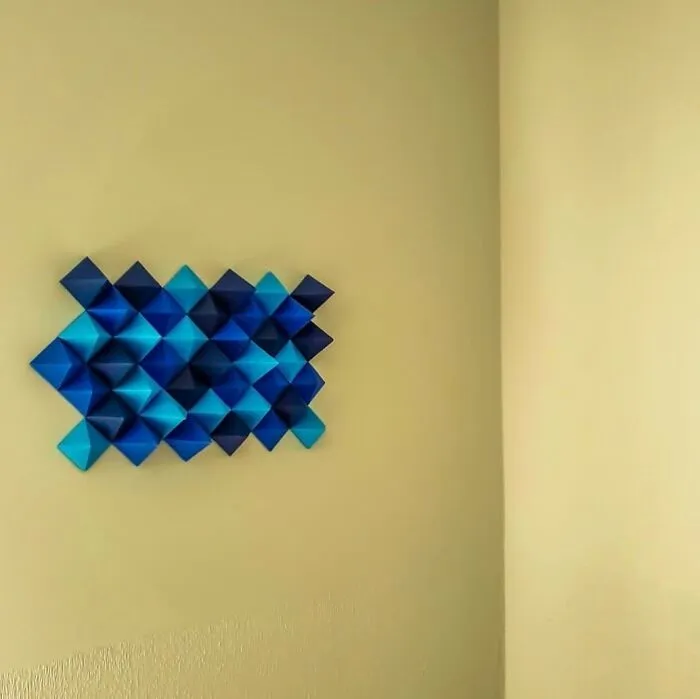 blue modular origami on a yellow wall