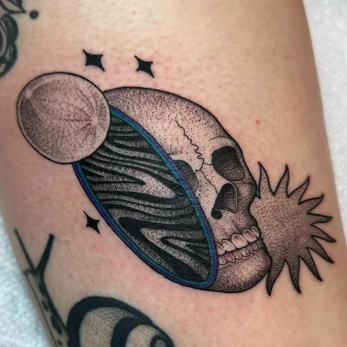 Skull and planet space tattoo with stars for astrology fans.