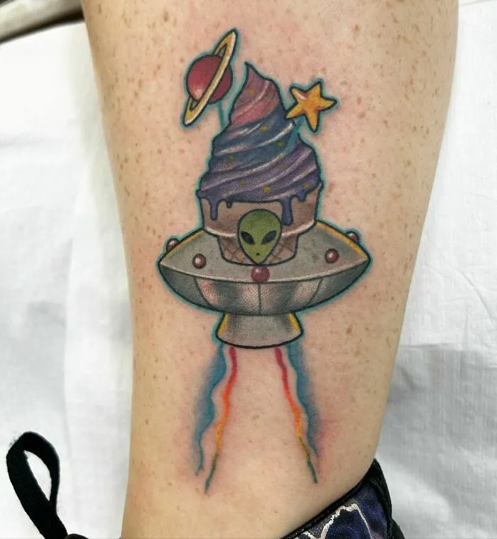 Space tattoo featuring an alien in a UFO topped with a galaxy swirl, Saturn, and star design.