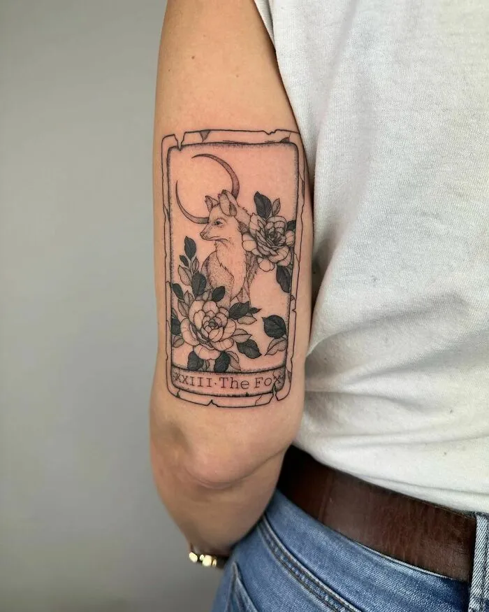 Floral tattoo with a fox design, showcasing elegance and beauty on upper arm.
