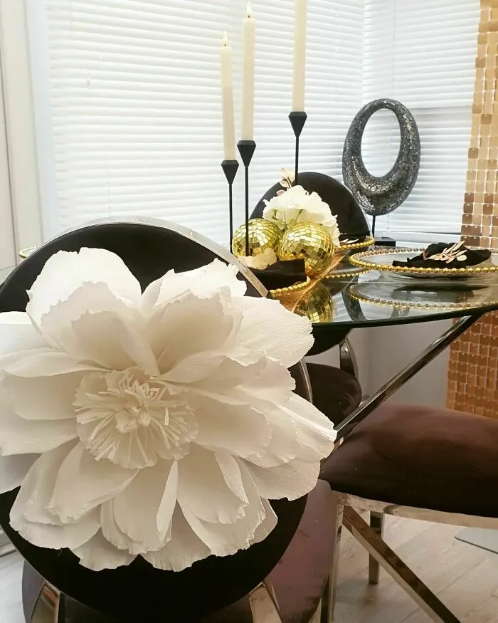 a big white paper flower near the table