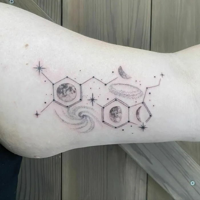 Space tattoo featuring planets, stars, and hexagonal designs on an arm for astrology fans.