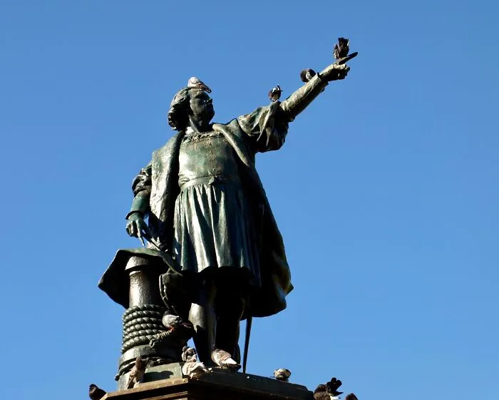 A Statue Of Christopher Columbus (Cristobal Colon) With Pigeons Perched On It