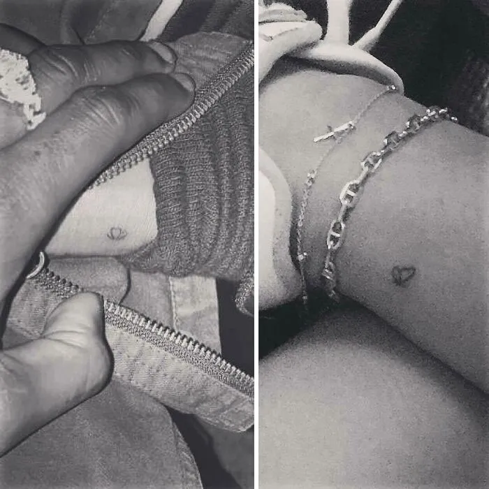 Close-up of small heart tattoos on wrists, adorned with a bracelet, featuring celebrity tattoo art.