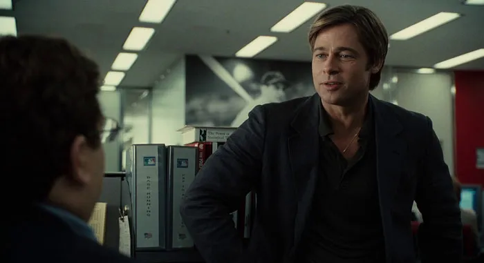 Actor Brad Pitt in a film scene, wearing a dark jacket, representing one of the highest-paid actors of all time.