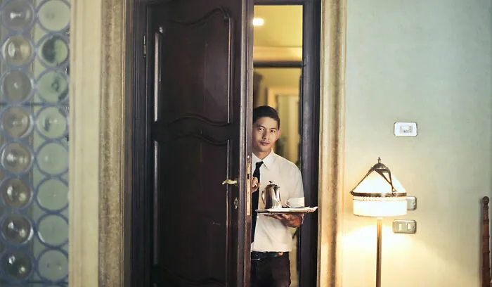 Hotel employee holding cup of coffee
