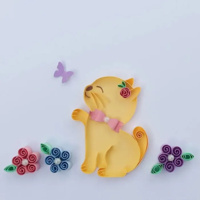 a yellow kitten made out of a paper with flowers and butterfly