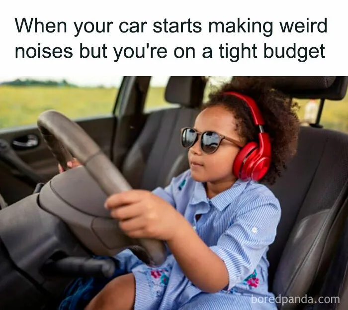 Child wearing sunglasses and headphones, sitting in a car, mimicking driving.