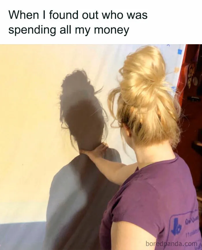 Woman pointing at her own shadow, illustrating a funny money meme.