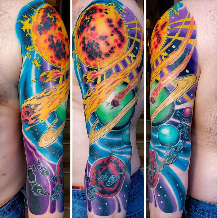 Colorful space tattoo featuring planets, asteroids, and a vibrant sun across a person's upper arm.