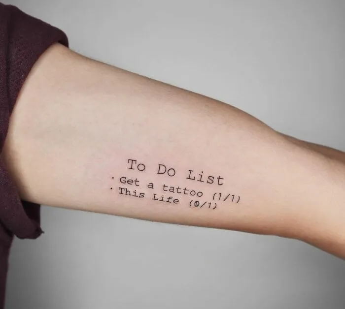 Arm with a humorous "To Do List" tattoo featuring tasks and check marks.