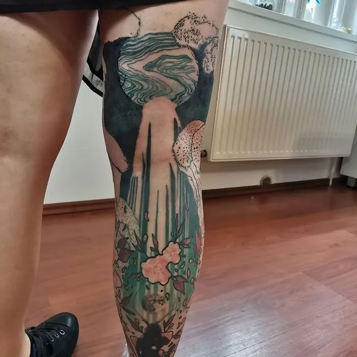 Lower leg tattoo featuring a waterfall design with natural and abstract elements.