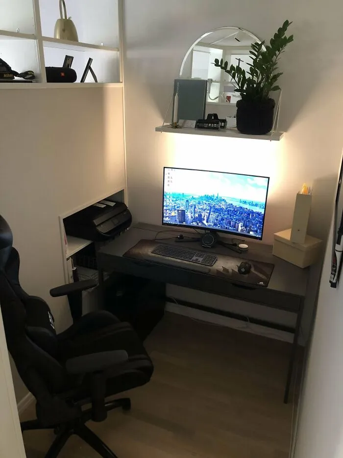 Compact home office setup with a desk, monitor, and potted plant enhancing home decoration ideas.