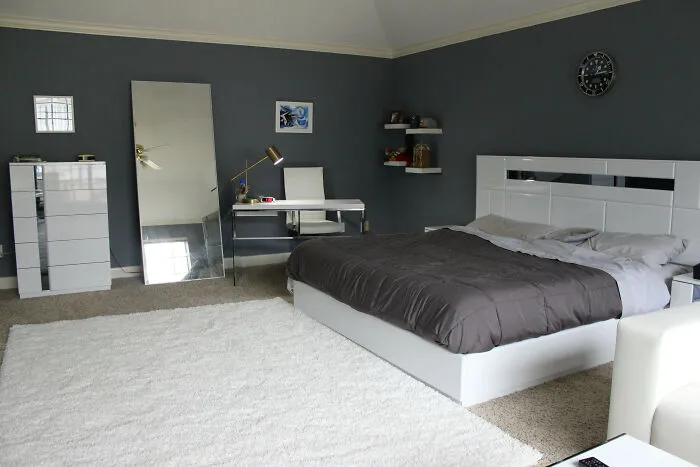 Modern bedroom with gray walls and white furniture, showcasing stylish home decoration ideas.