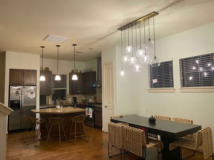 Modern kitchen and dining area with stylish lighting, wooden floors, and contemporary decor elements for home decoration ideas.