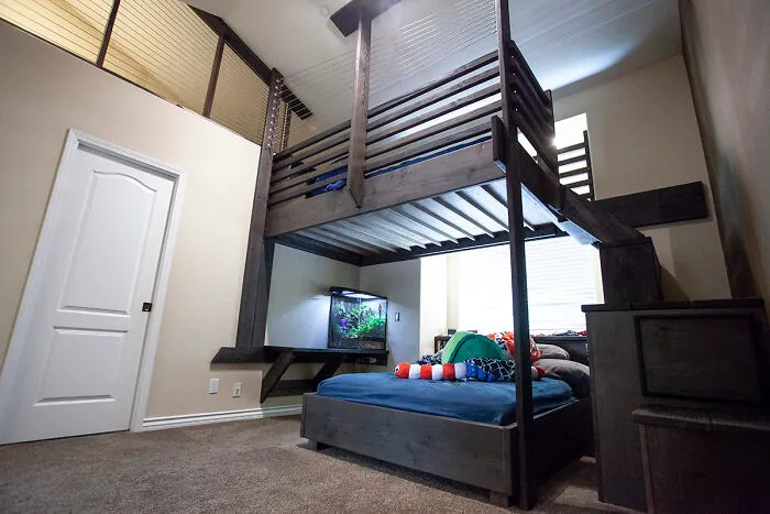 Loft bed with aquarium underneath in modern home decor setup.