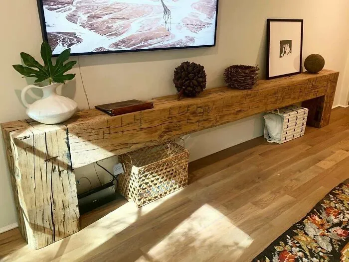 Rustic wooden console table with decor under a wall-mounted TV for home decoration ideas.
