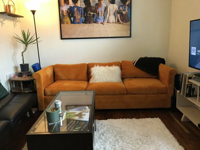 Cozy living room with a mustard sofa, wall art, and modern decor elements.