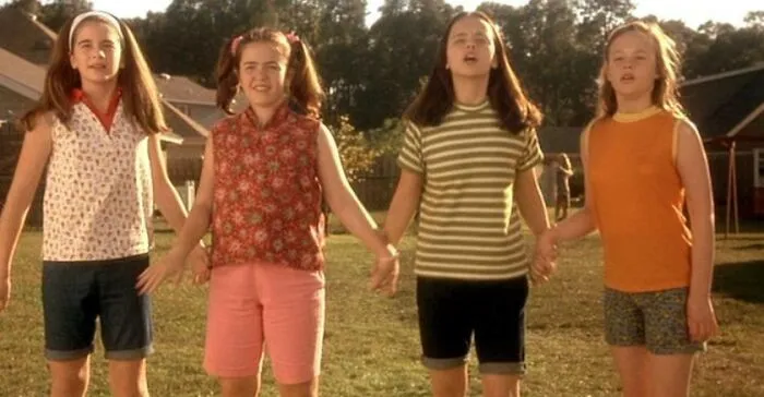 Four kids holding hands outdoors, illustrating a friendship duo moment.