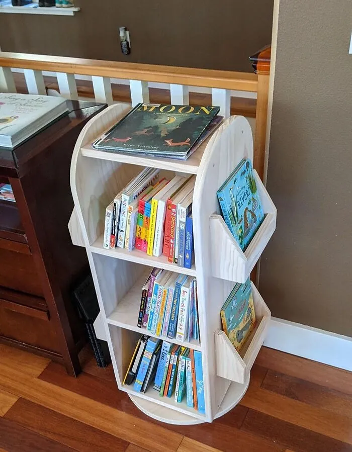 Wooden rotating bookshelf filled with children's books, enhancing home decoration.