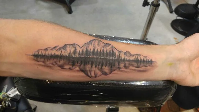 A Soundwave That Turns Into Trees And Mountains Reflected On Water. Done By Ben At Chalice In Boise, Id