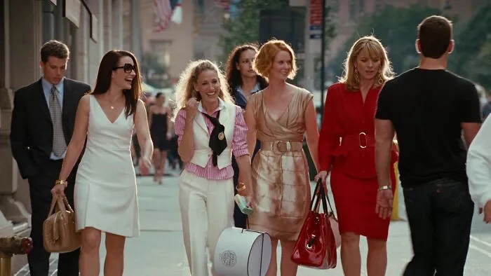 Iconic best friend duo walking with friends on a city street, dressed in stylish outfits, sharing laughter and good times.