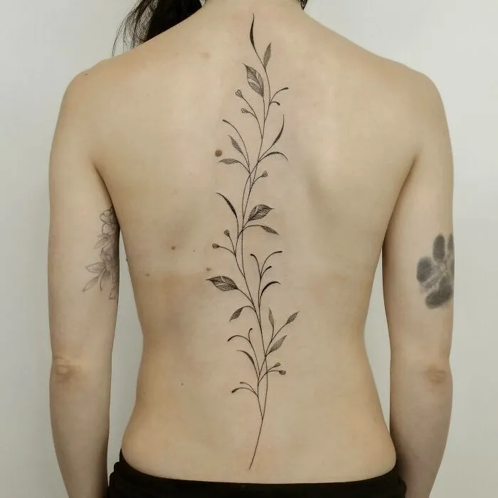 Elegant floral spine tattoo design on a person's back, showcasing beautiful body art.
