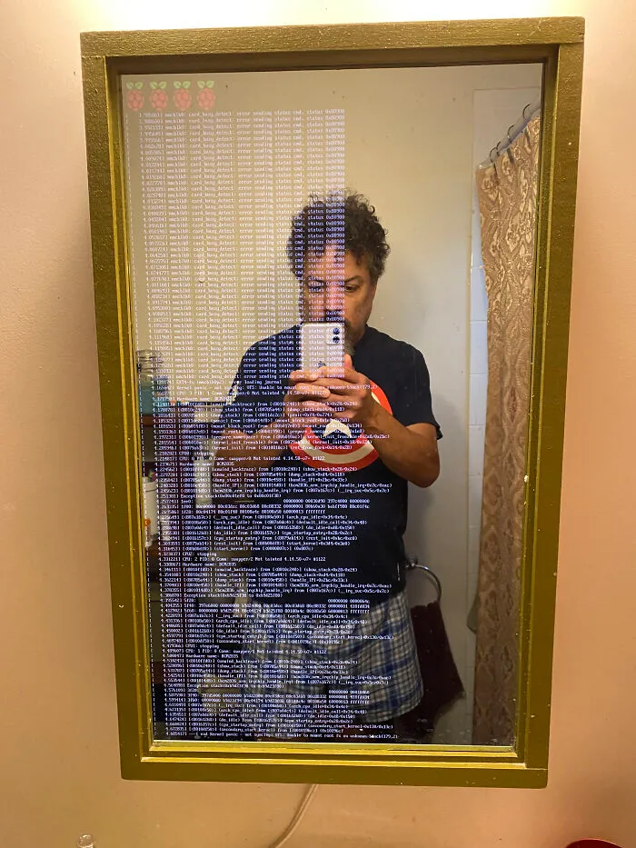 Man posing in front of a broken smart mirror 