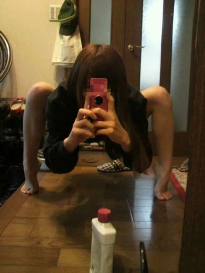 Scary mirror picture of a woman standing like a spider 
