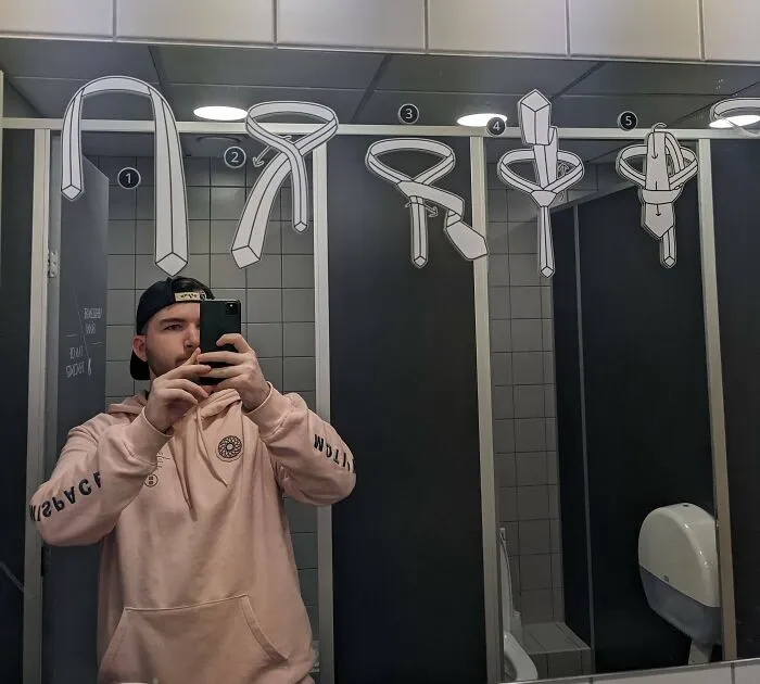 Man taking a picture of a tying a tie instruction 