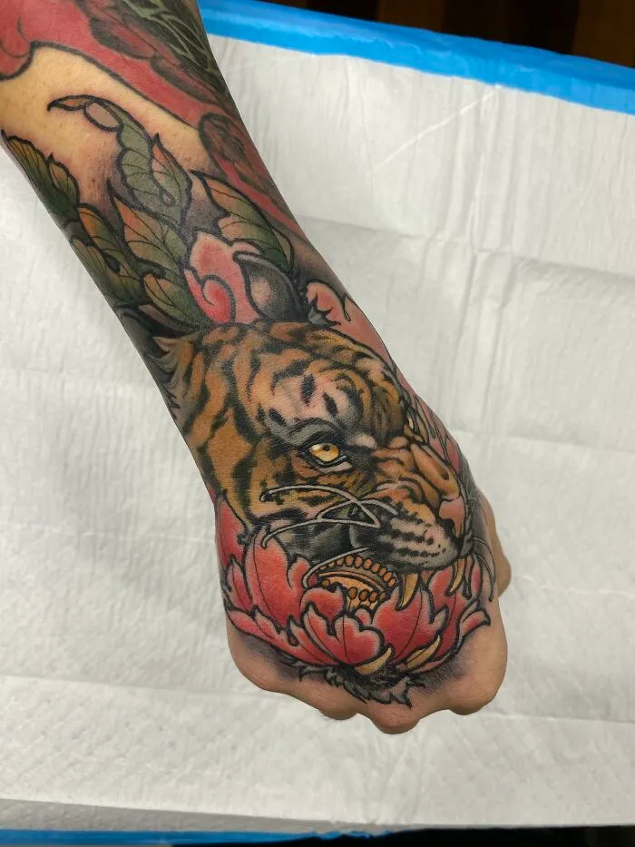 Tiger wrist tattoo design with vibrant colors and intricate details.