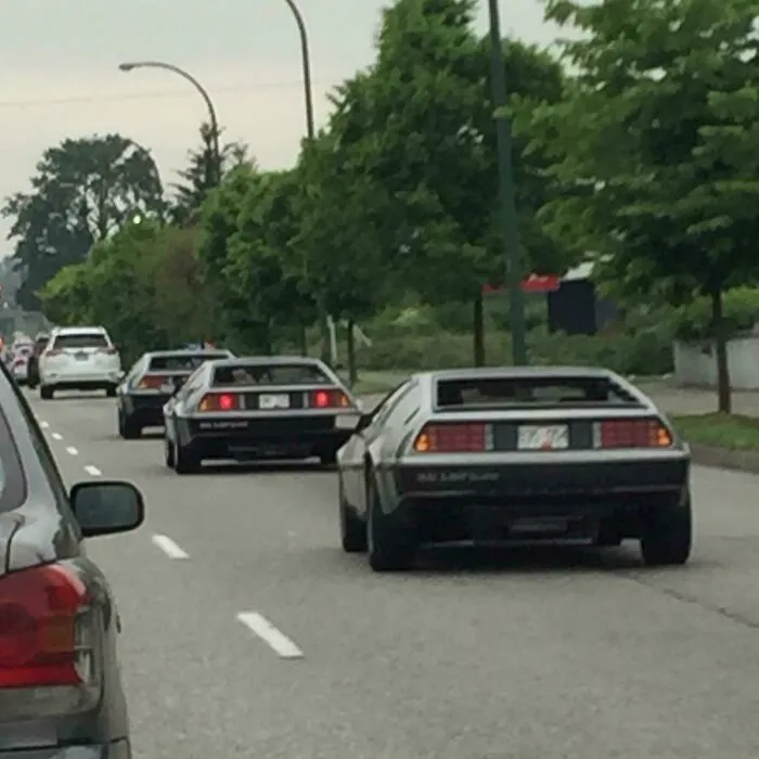 Tres Deloreans conduciendo en fila