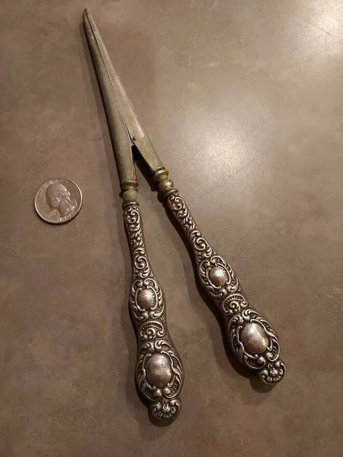 Abrazadera antigua con mango de plata de algún tipo. La punta de la pinza es hueca, por lo que no es umbilical. La pinza no se abre del todo. Cuarto de dólar para la escala