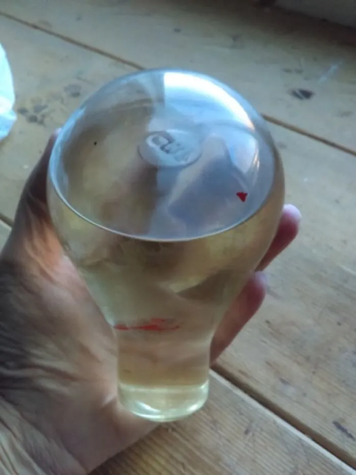 Bombilla de vidrio, llena de líquido, disco metálico flotante en el interior