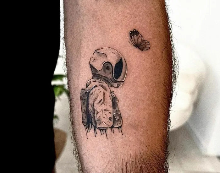 Astronaut tattoo with butterfly on arm, ideal for astrology fans and space enthusiasts.