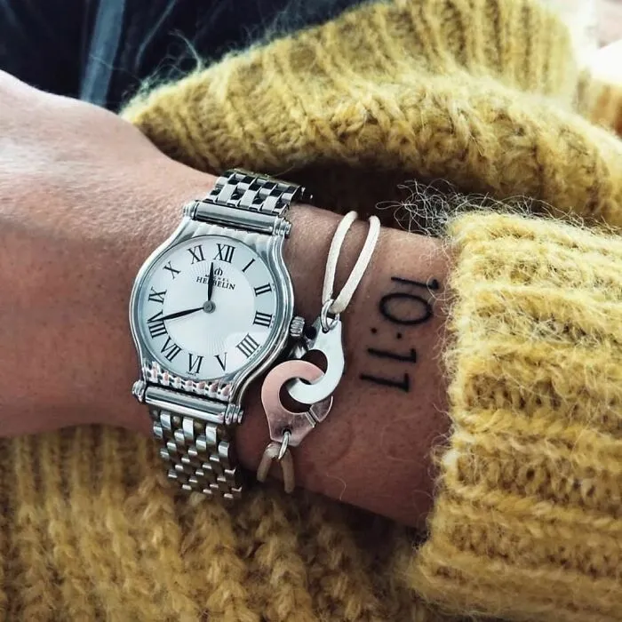 Wrist tattoo design with a small heart symbol alongside a watch and bracelet.