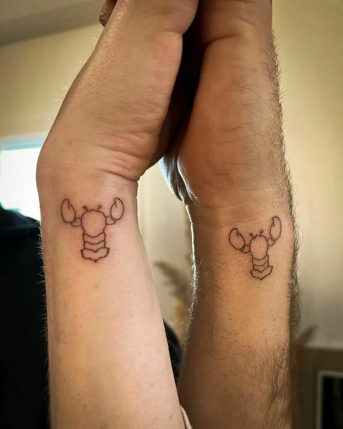 Minimalist lobster wrist tattoo designs on two wrists.