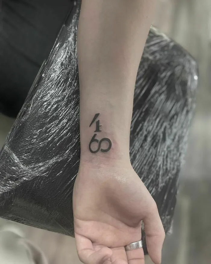 Wrist tattoo design with numbers 4169 on inner forearm.