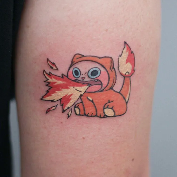 Adorable animal-themed cat tattoo breathing fire on skin.