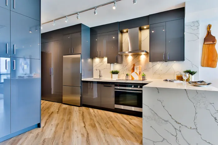 Modern kitchen with sleek cabinets, marble countertops, and wooden flooring, showcasing stylish home decoration ideas.