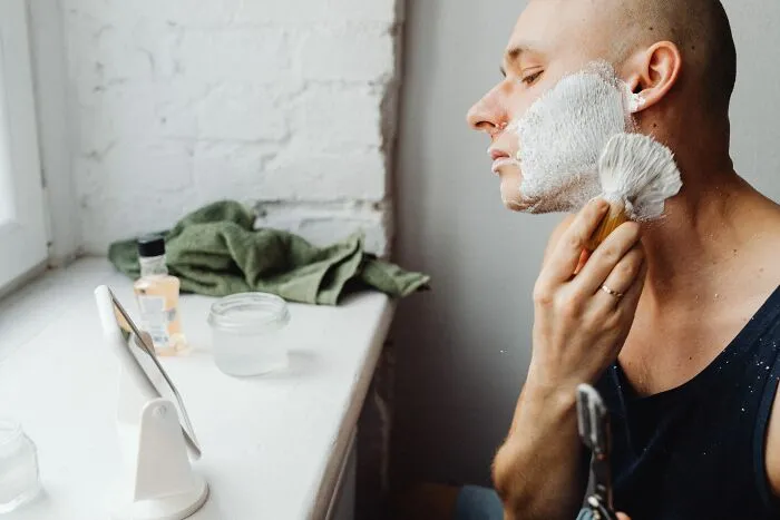 Man Shaving In Front Of The Mirror