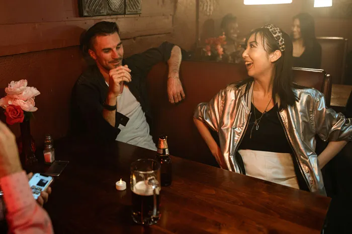 Two people enjoying a lively conversation in a cozy bar setting; exploring relationship myths and dynamics.