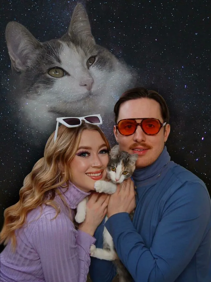 A couple holding one of the cutest cats ever to melt your heart with a large cat face and starry background.