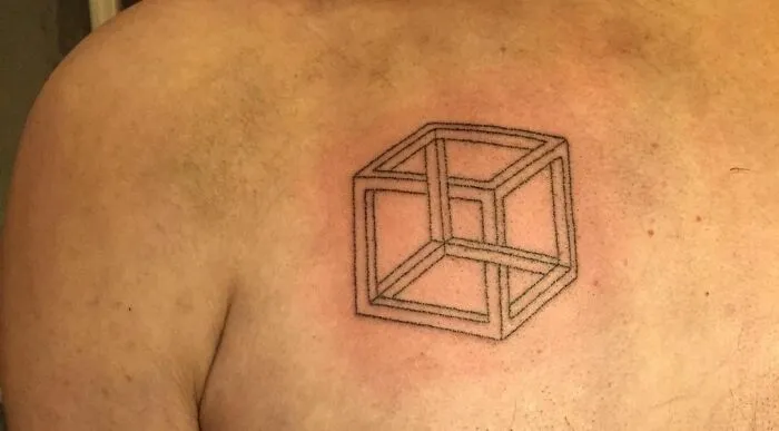 Optical illusion tattoo of a geometric cube design on a person's skin.