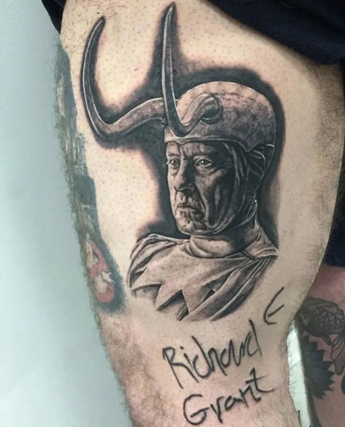 Marvel tattoo of a character with horned helmet on a person's leg.