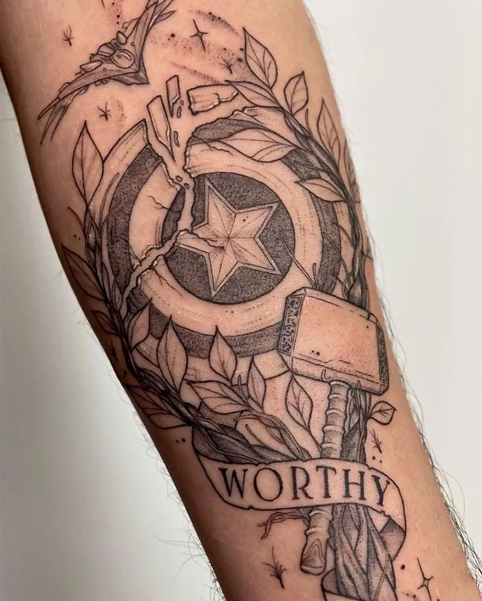 Marvel tattoo featuring Thor’s hammer and Captain America's shield with "Worthy" banner.