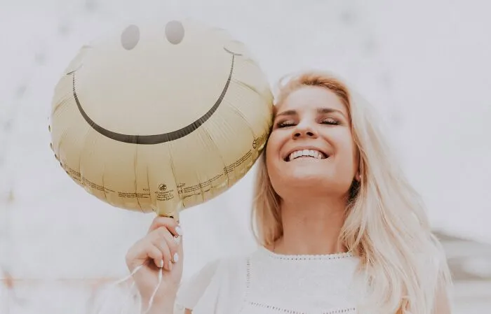 Woman smilling and holding a balloon 